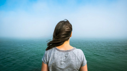 Woman facing the sea.