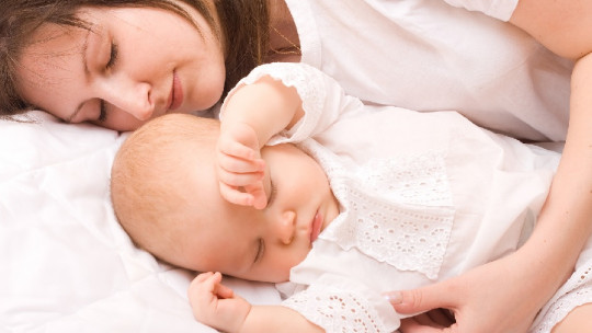 Mother sleeping with her baby.