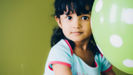 Little girl playing with a balloon.