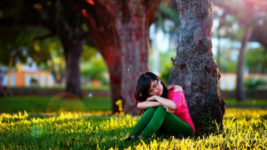 Woman sitting under a tree.