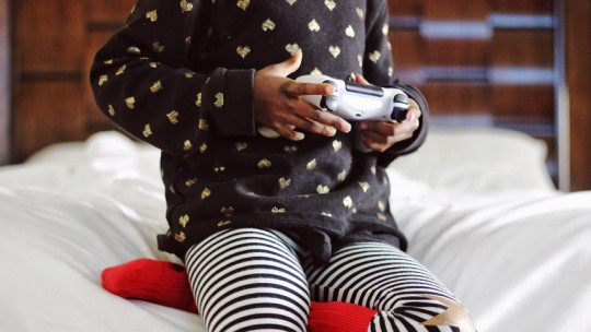 Little girl playing with a video game console.